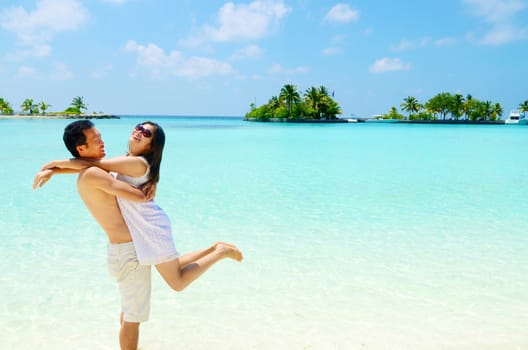 Young happy asian couple on white beach at summer vacation