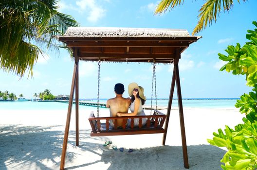 Asian couple on a tropical beach at Maldives.Travel magazine concept.