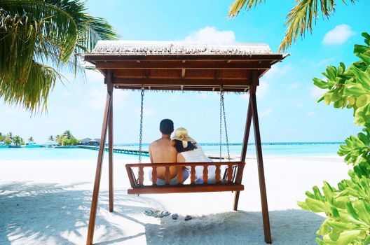 Asian couple on a tropical beach at Maldives.Travel magazine concept.