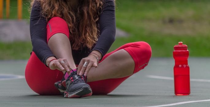 Woman adjusting her tennis shoes before running