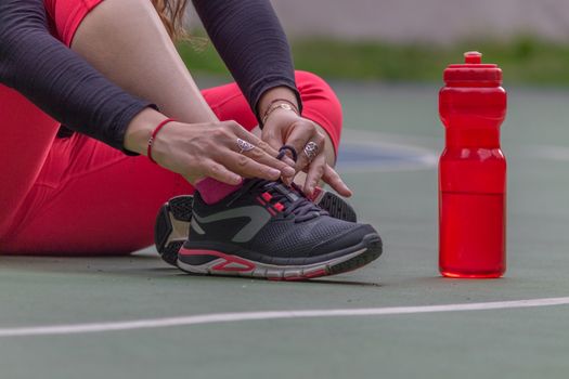 Woman adjusting her tennis shoes before running