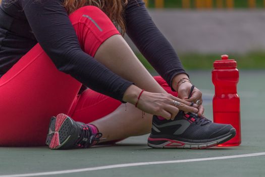 Woman adjusting her tennis shoes before running