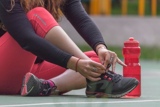 Woman adjusting her tennis shoes before running