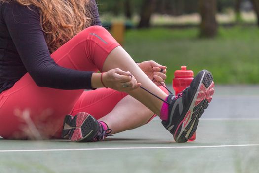 Woman adjusting her tennis shoes before running