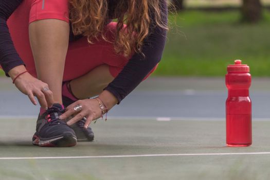 Woman adjusting her tennis shoes before running