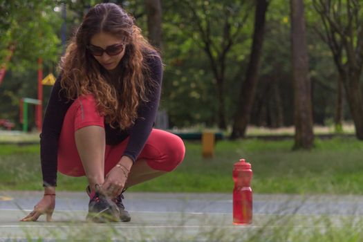 Woman adjusting her tennis shoes before running