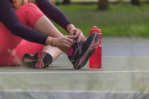Woman adjusting her tennis shoes before running