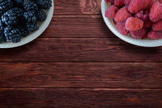 Blackberries and raspberries on rustic wooden table