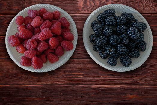 Blackberries and raspberries on rustic wooden table