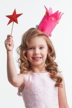 Beautiful little candy princess girl in crown holding star shaped magic wand