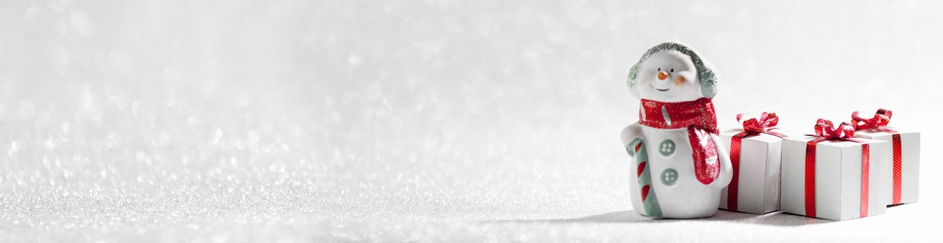 Christmas Snowman toy and gifts on silver glitter background