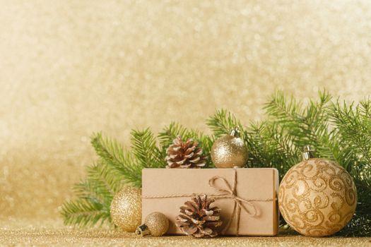 Christmas toys, decorations, present gift box wrapped in kraft paper on golden glitter background, copy space