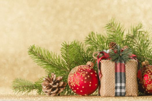 Christmas toys, decorations, present gift box wrapped in kraft paper on golden glitter background, copy space