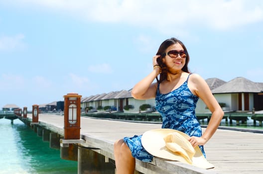 Asian girl sitting and relaxing at  luxury resort, Maldives