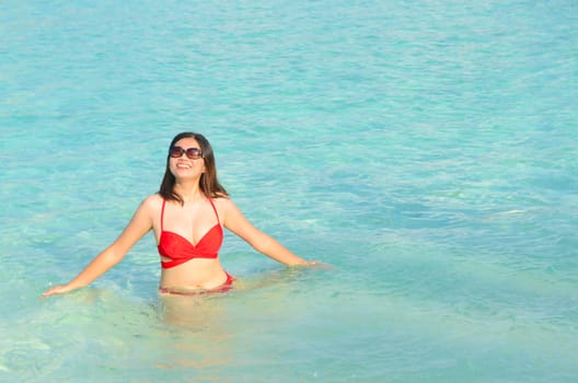 Woman swim and relax in the crystal-blue sea of tropical beach at  Maldives islands. Happy lifestyle concept. 