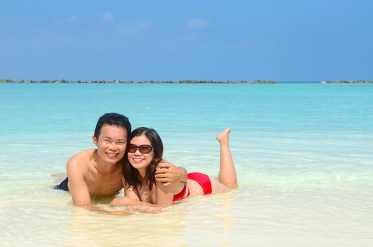 happy asian couple  in clean water at summer vacation in Maldives island