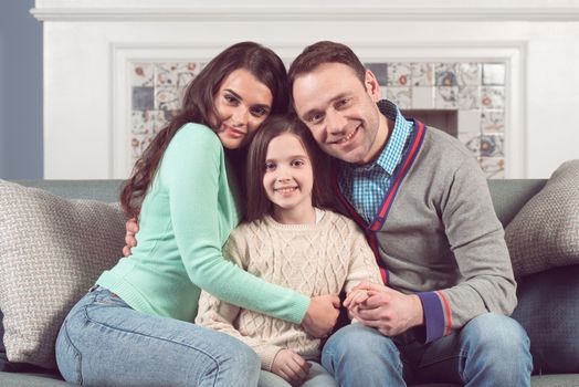 Portrait of a smiling family with child at home
