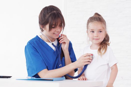 Young smiling female doctor and her little patient 