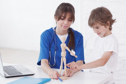 Doctor explain medicine to child using wooden doll