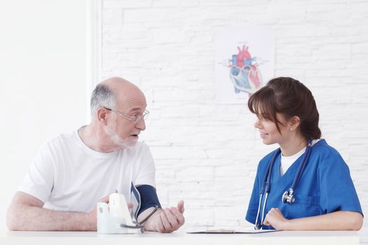 Doctor measuring blood pressure of male senior patient