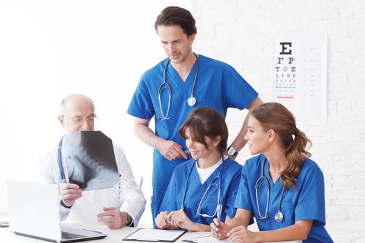 Medical team checking on X-ray results isolated on white