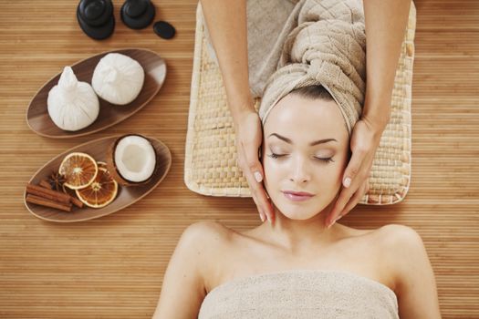 Beautiful young woman relaxing in spa salon