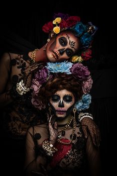 Closeup portrait of a woman with a sugar skull makeup dressed with flower crown. Halloween concept