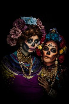 Closeup portrait of a woman with a sugar skull makeup dressed with flower crown. Halloween concept