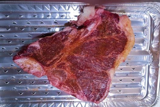 Close-up view of a Marbled Bone steak on an alu grill cup