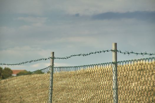 wire mesh and barbed wire with macro shot and in the background the blue of the sky, ideal as texture, and as a sense of desire for freedom.