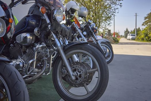 set of vintage custom motorcycles parked in a rally in italy.