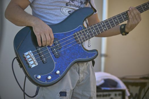 Detail of a Guitarist who plays his electric guitar at a live rock music concert.