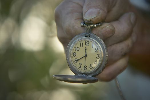 Hand held vintage pocket watch for watch. A symbol of the time passes and the hurry that too many people always have.