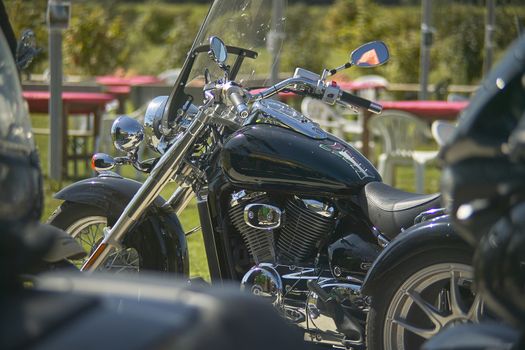 Detail of the tank and engine of a custom black motorcycle.