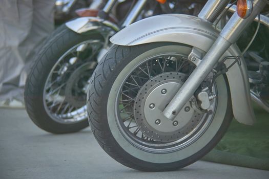 detail of a wheel of a vintage motorcycle with well visible disc brake and tread details.