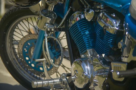 Engine of a colorful custom blue motorcycle, with glittering chromes, a symbol of how much passion can lead to detailing.