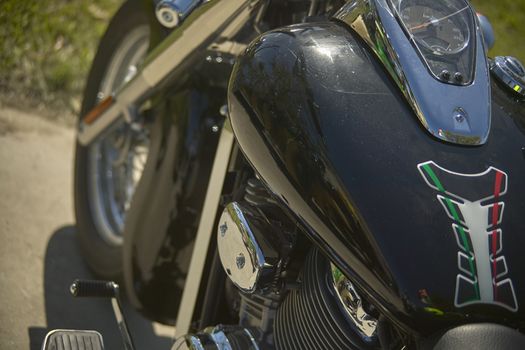 detail of the tank and part of the engine head of a custom black bike.