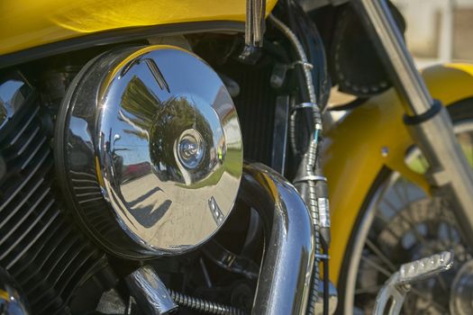 Detail of engine and chromed suction filter of a vintage yellow custom motorcycle. Custom vintage motorcycle, chrome and motorcycle