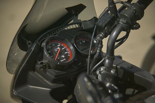 speedometer of a modern enduro bike, detail of the instrument cluster with a handlebars and a well-visible brake pump.