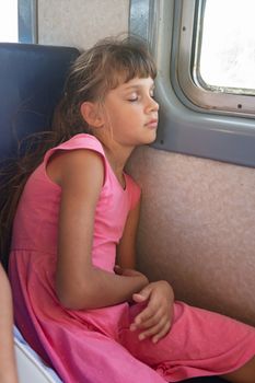 Tired girl fell asleep in an electric train