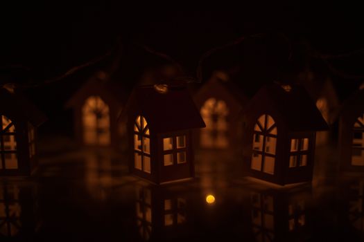 Christmas card of small glowing toy houses garland with copy space for text