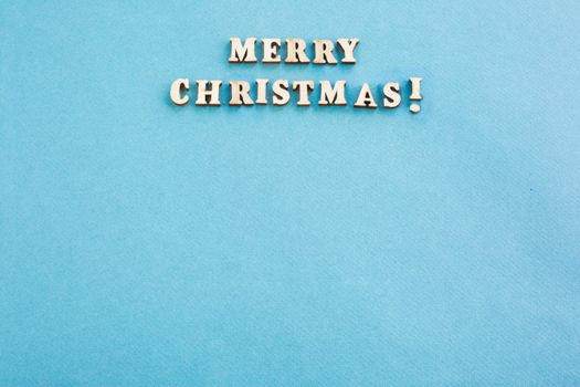 Merry Christmas sign small wooden decor on blue paper card background