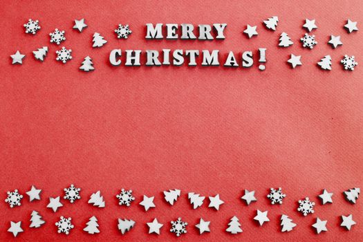 Merry Christmas sign and small wooden decor on red paper card background