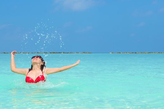 Woman swim and relax in the crystal-blue sea of tropical beach at  Maldives islands. Happy lifestyle concept. 