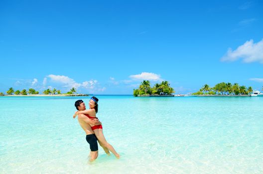 Young happy asian couple  in clean water at summer vacation in Maldives island