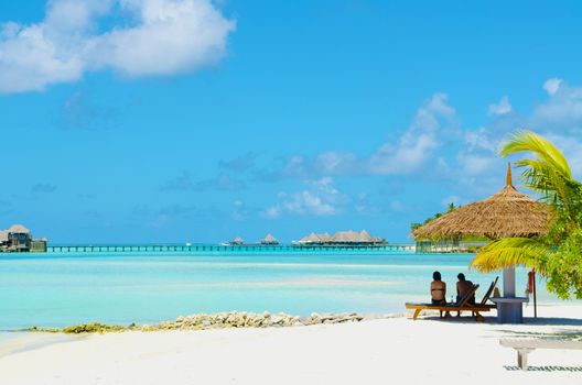 Asian couple on a tropical beach at Maldives.Travel magazine concept.