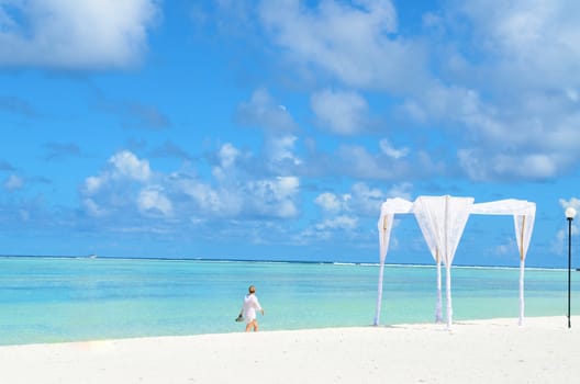 Beautiful young woman on the beach with clean blue water and clear sky