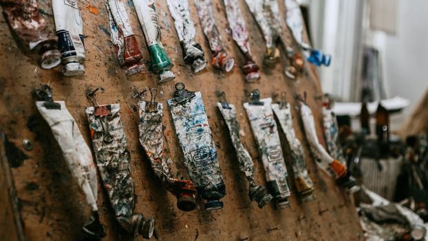 Tubes of oil paint on wooden table in art workshop