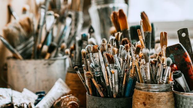 Table with brushes and tools in an art workshop. Background.