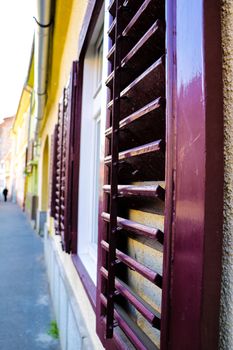 Typical architectural details of a facade of the building in the old city. An ancient wooden sun blind at windows